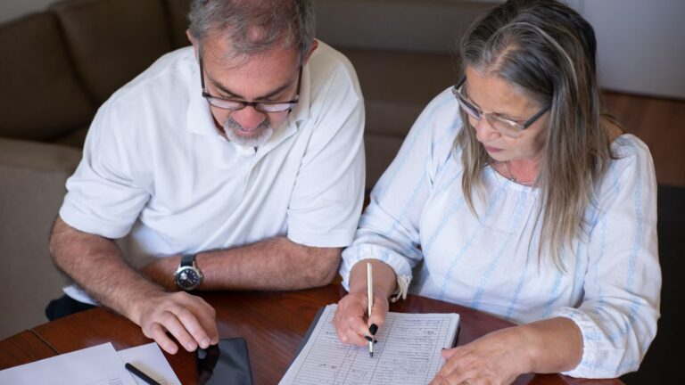 Acting on tax speculation when taking pension cash can cause later harm Acting on tax speculation when taking pension cash can cause later harm: an older couple going through pension and retirement paperwork together at home